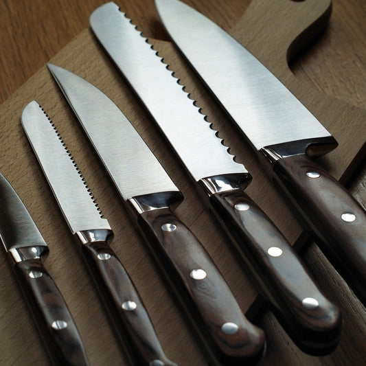 Chef's knife, boning knife, and paring knife on a cutting board.